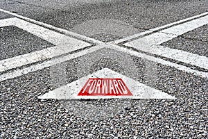 The word forward written on asphalt road with direction arrows. Moving forward in business or life