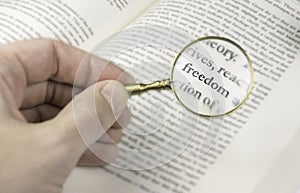 The word freedom read through a magnifying glass