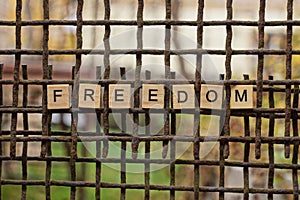 The word freedom from wooden letters on the iron bars