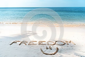 The word freedom written in the sand on a tropical beach, lifestyle vacation and travel design concept