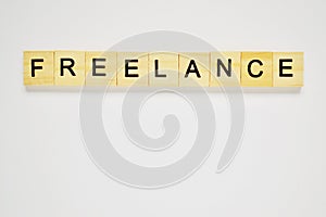 Word freelance. Top view of wooden blocks with letters on white surface