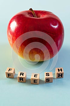 The word fresh written in cubes and an apple