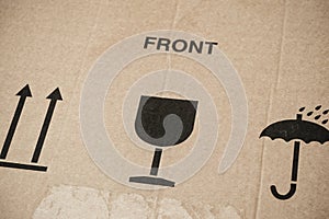 Word Front and three symbols on cardboard box - This Way Up, Keep Dry and Fragile for careful transportation