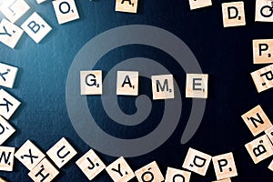 Word GAME with wooden letters on black Board with dice and letter in the circle