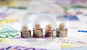 Word Geld on coin stacks, cash background photo
