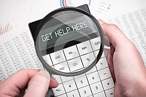 The word get help here is written on the calculator. Business man holding a calculator in his hand