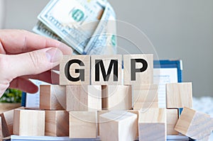 The word GMP on the wooden blocks and money in the background