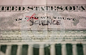 Word God crossed out and replaced by science on a US dollar bill