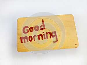 The word good morning is brown on the wood.