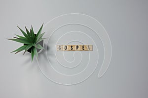 The word Gospel written in wooden letter tiles on a white background