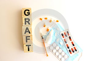 The word GRAFT is made of wooden cubes on a white background. Medical concept.