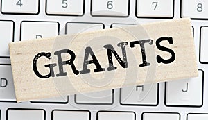The word GRANTS on a wooden block