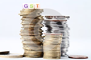 Word GST with stack of coins