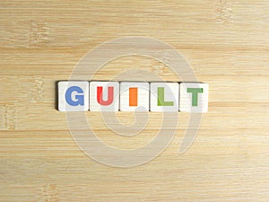 Word Guilt on wood background photo