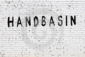 Word handbasin painted on white brick wall