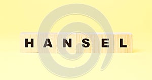 Word hansel with black letters on wooden cubes on yellow