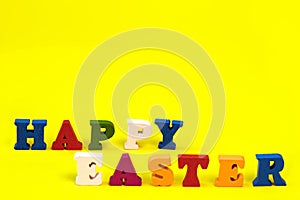 Word Happy Easter of colorful toy alphabet letters isolated on yellow background