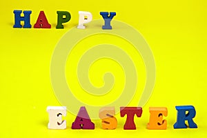 Word Happy Easter of colorful toy alphabet letters isolated on yellow background