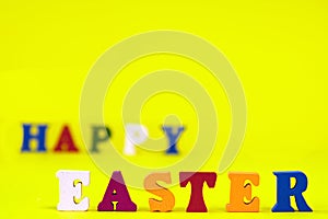 Word Happy Easter of colorful toy alphabet letters isolated on yellow background