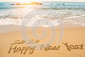 Write 2020 happy new year on beach photo