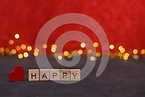the word happy on wooden blocks. red background