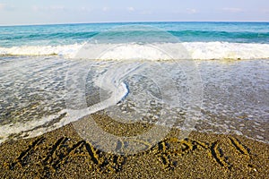 Word happy! written on sand