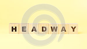 Word headway made with small wooden blocks on yellow