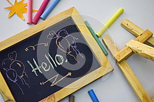 Word `Hello` written on blackboard with colorful chalk.