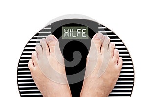 Word Help written in German (Hilfe) on a weight scale photo