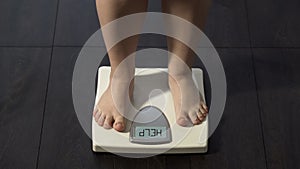 Word help written on scales screen, fat woman measuring weight, obesity problem