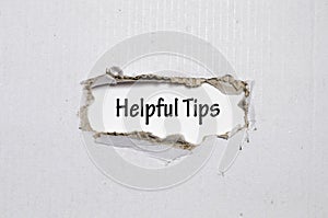 The word helpful tips appearing behind torn paper photo