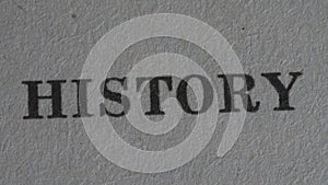 The word `history` is printed on a piece of paper, close-up.