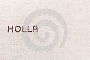 The word Holla written with coffee beans shot from above, aligned to the left