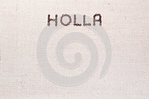 The word Holla written with coffee beans shot from above, aligned at the top