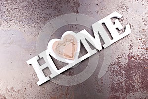 The word Home in white letters on rusty background