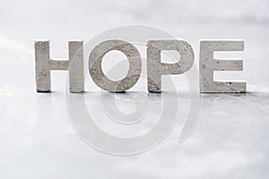 Word HOPE made with cement letters on grey marble background. Copy space. Biblical, spiritual or christian reminder