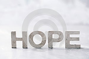 Word HOPE made with cement letters on grey marble background. Copy space. Biblical, spiritual or christian reminder