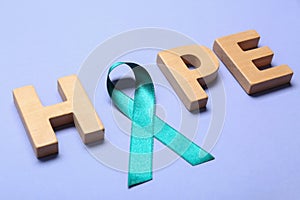 Word Hope made of wooden letters and teal awareness ribbon. Symbol of social and medical issues