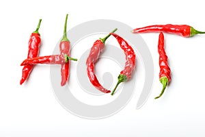 Word hot from red spicy chili peppers over white