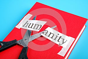 The word humanity is cut with scissors on a red book
