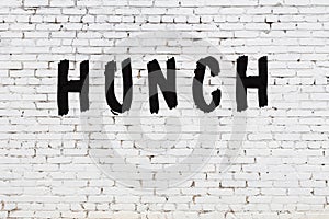 Word hunch painted on white brick wall