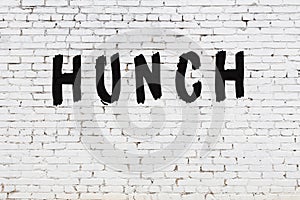 Word hunch painted on white brick wall photo
