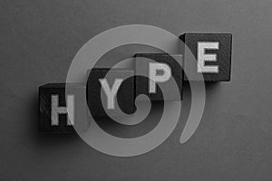 Word Hype of black cubes with letters on grey background, top view