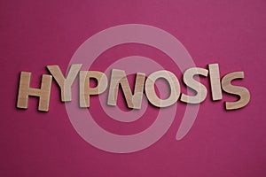 Word HYPNOSIS made with letters on magenta background, flat lay