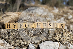The word Hypothesis was created from wooden cubes. Photographed on the wall.