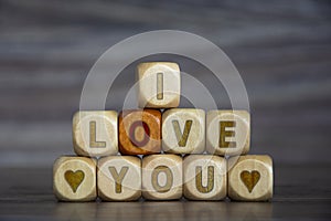 Word I LOVE YOU on wooden cubes on blurred background. Declaration of love. Defocusing, concept. Alphabet letter blocks on wooden