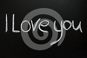 The word i love you written in white chalk on a black chalkboard