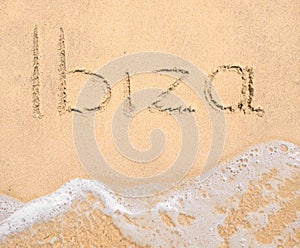 The word Ibiza written in the sand on beach