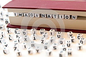 Word imagination written with letters between a book pages white background with letters spread around education reading concept