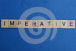 Word imperative from small gray wooden letters